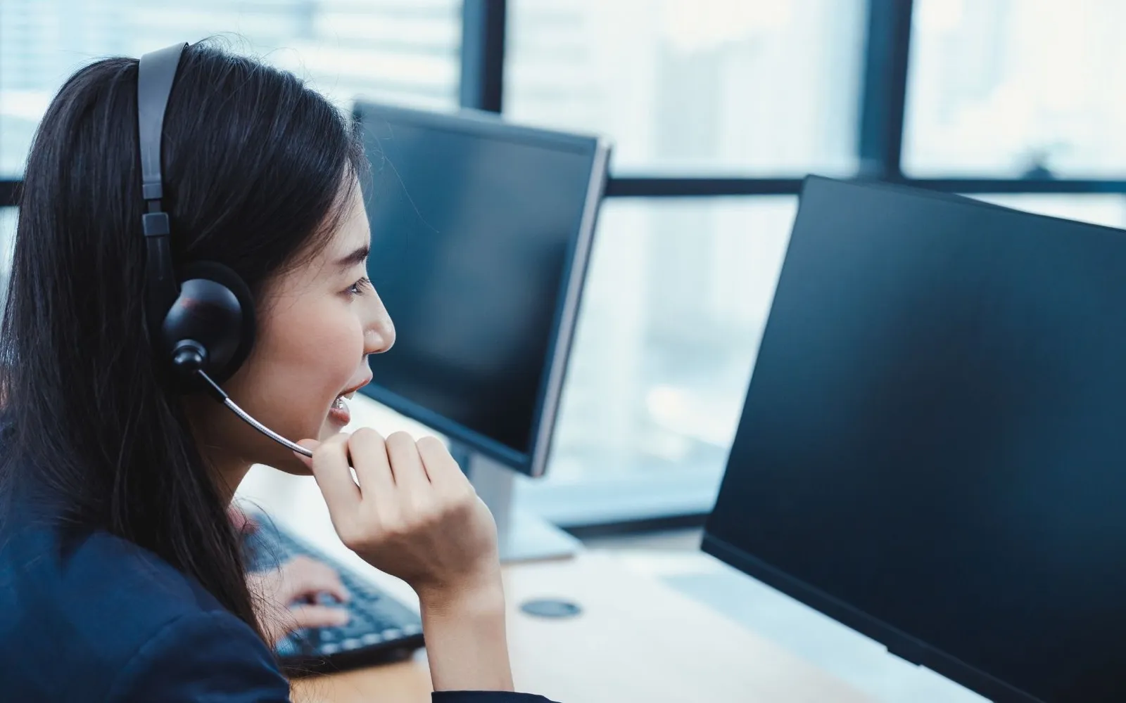 Support-Mitarbeiterin mit Headset am Arbeitsplatz